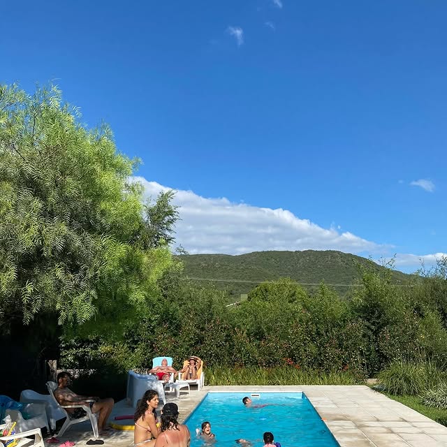 Familias disfrutando de la piscina con vista a las montañas
